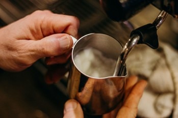 Milk frother, frothing milk in a jug