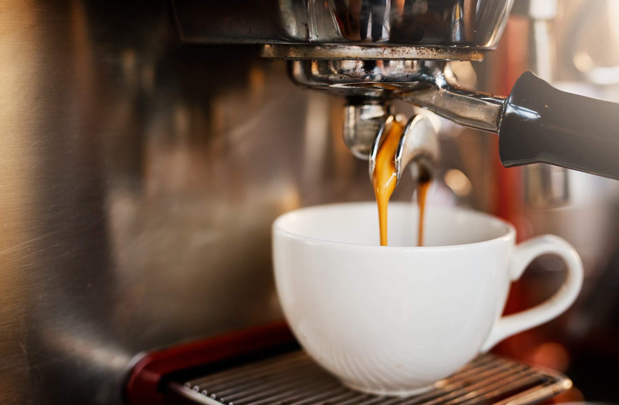 A mug of coffee being prepared in a professional coffee machine