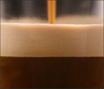 Close-up of a Starbucks coffee being brewed into a cup.