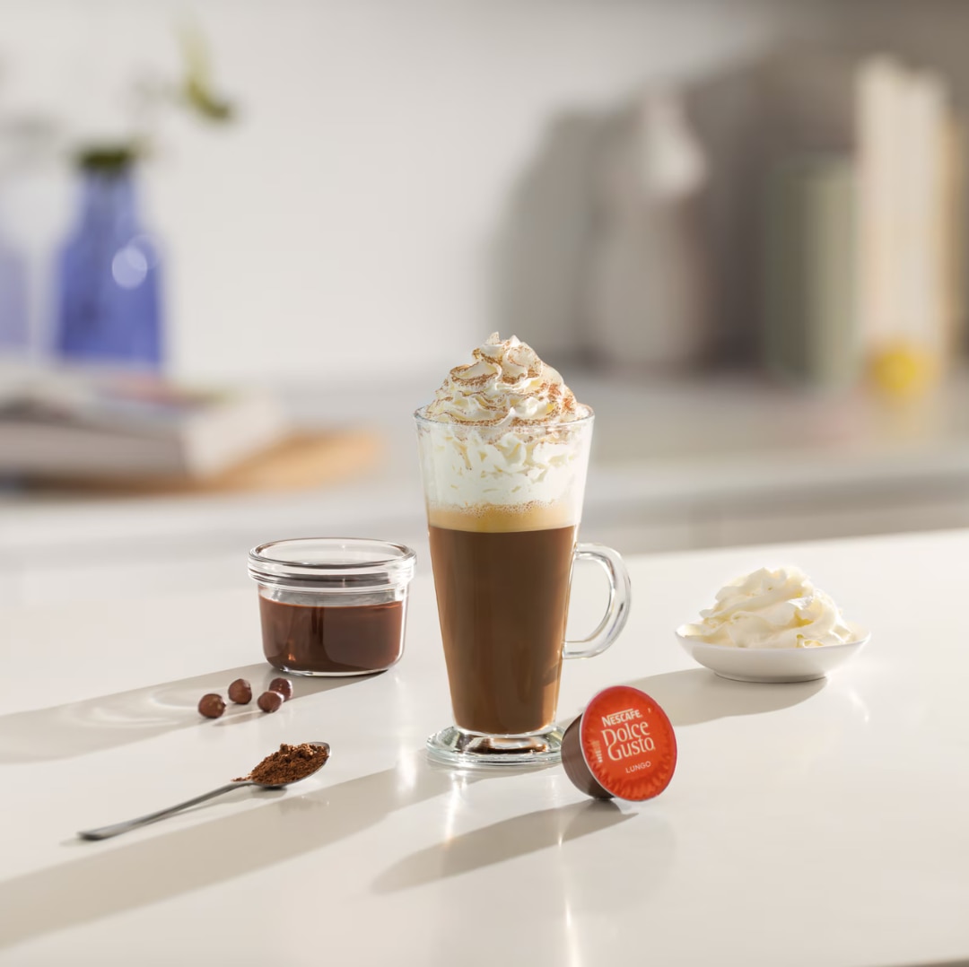 iced cappuccino next to a coffee capsule