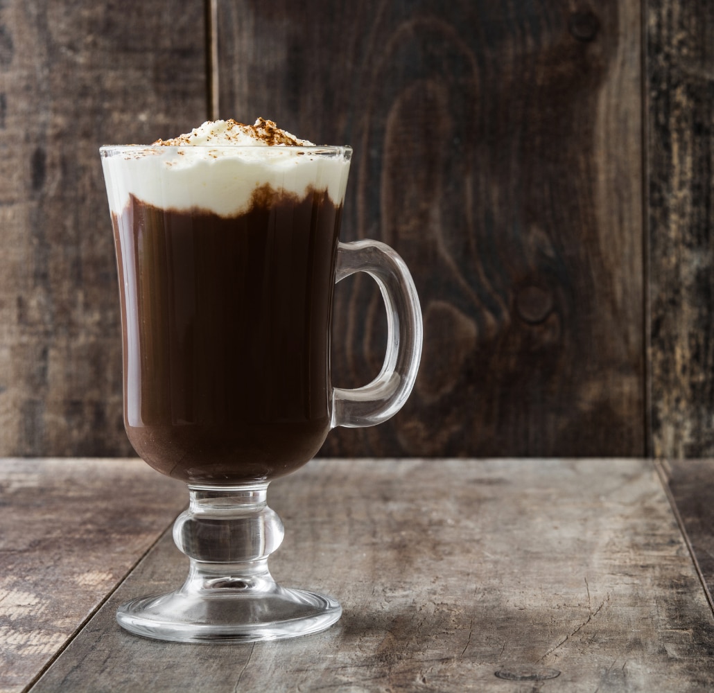 an Irish coffee in a white and green cup