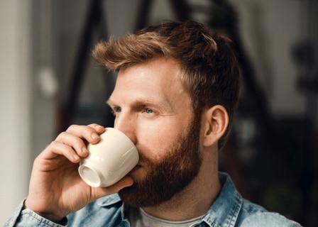 man drinking a cup of coffee